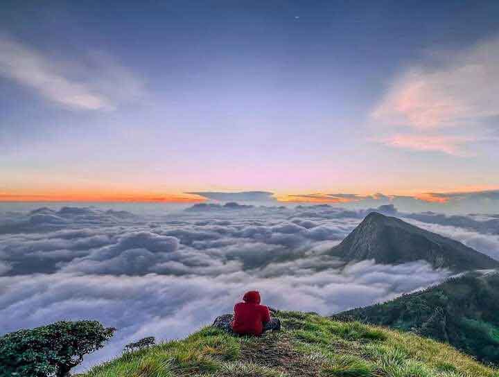 Kolukkumalai sunrise with floating clouds and mountains