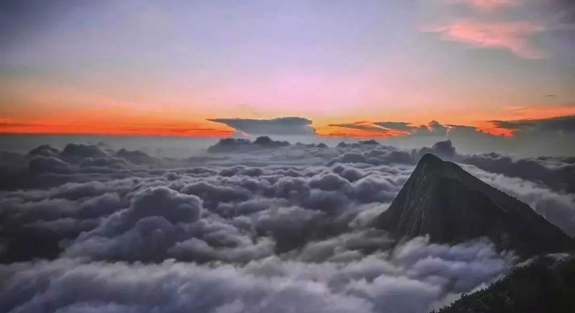 Kolukkumalai sunrise view with misty hills in Munnar