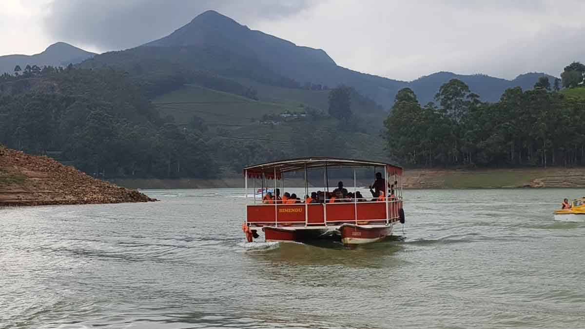 Row boat in Mattupetty Dam surrounded by tea gardens