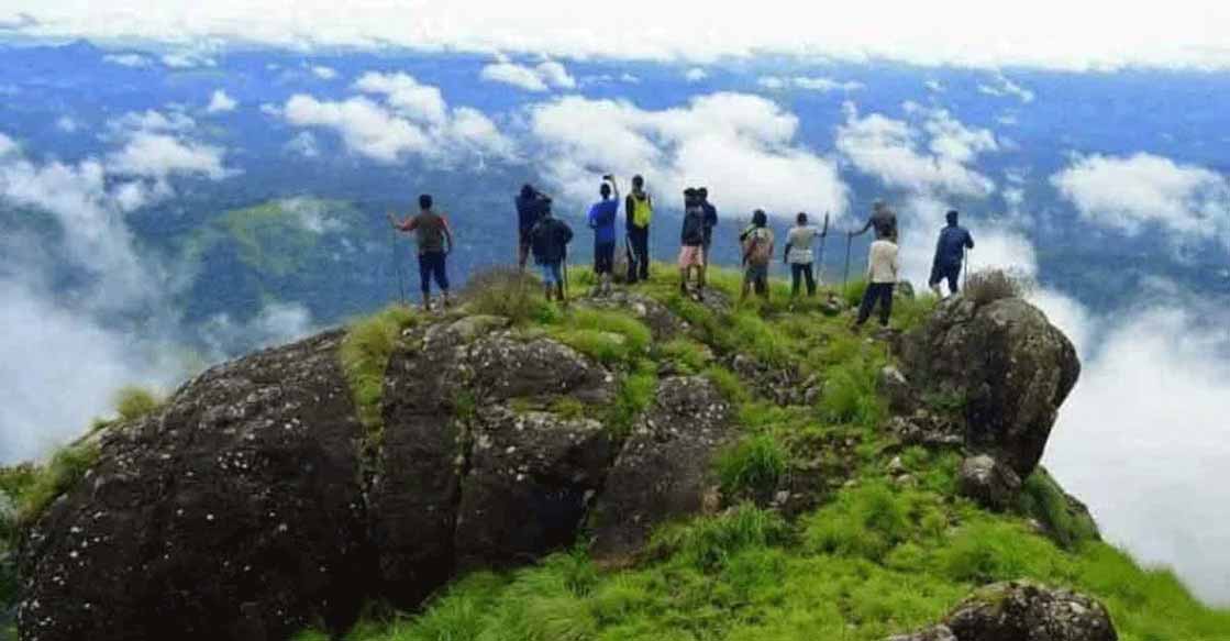 Steep Chokramudi peak trek through forested with rocks and grasslands slopes in Munnar