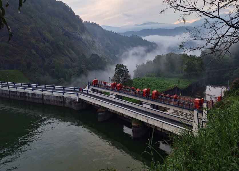 Ponmudi Dam reservoir with tea-covered hills and reflections near Munnar