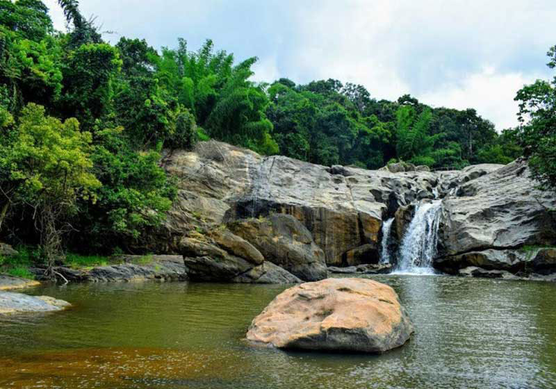 Ripple Waterfall cascading over rocks with lush greenery near Munnar