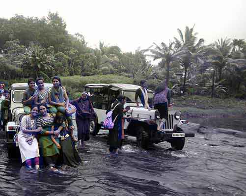 Tourists experiencing river crossing adventure in Munnar